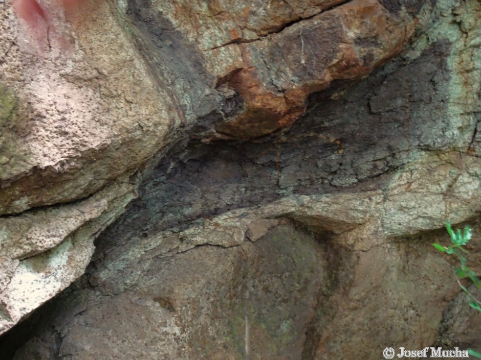 Kozlí hora - Hudlice - výplň mezi polštáři - brekcie tvořená směsí kousků a střípků lávy a částečně břidlicemi vytvořených ze sedimentů bahnitého dna stmelených kalcitem nebo křemenem.  