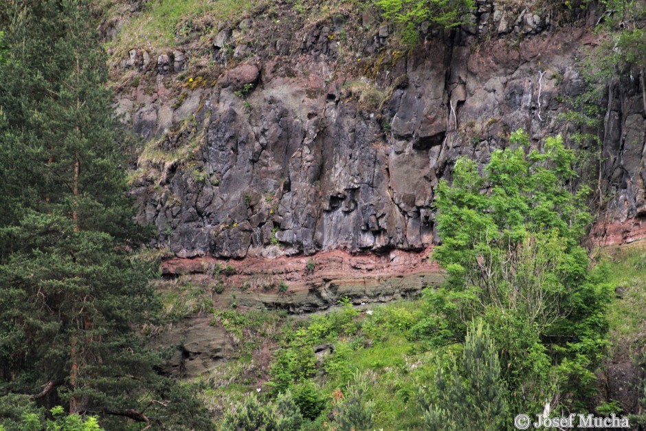 Vojkovická skála - sedimenty tufů a pyroklastik (zelenavé jemnozrnné sedimenty pod červenohnědou vrstvou) s čedičovým lávovým proudem