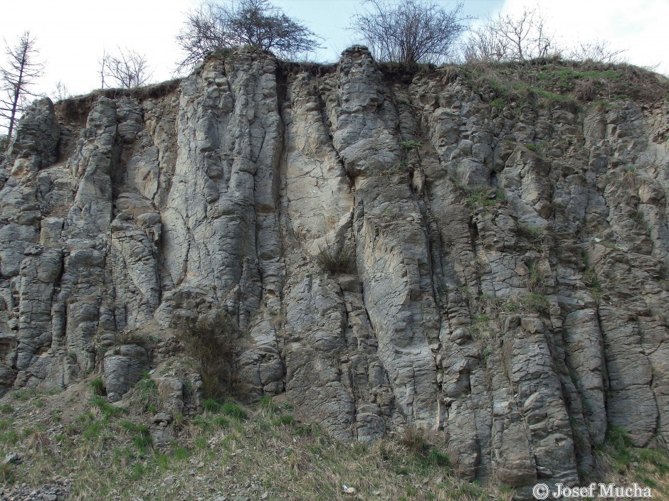 Lom Holý vrch u Ratiboře - čedič stáří 15 - 20 mil. let proráží horniny tepelského krystalinika typu svorových fylitú z období neoproterozoika (konec starohor) - stáří více než 600 mil. let