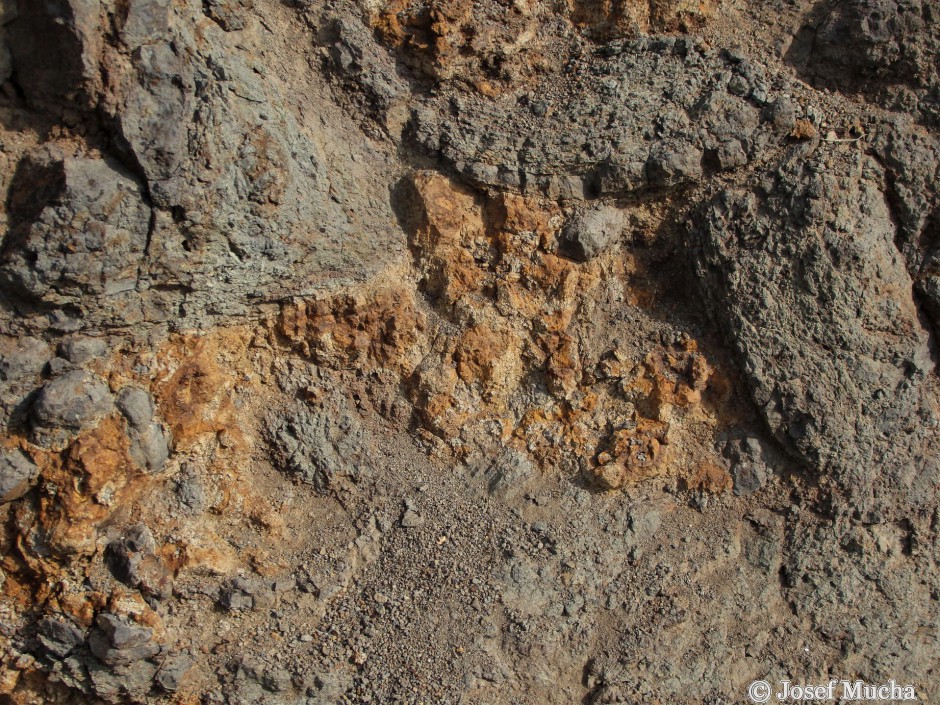 Vrch Homole - alterované bazalty, žlutobílošedé jílovité minerály s cibulovitou odlučností bazaltu - detail